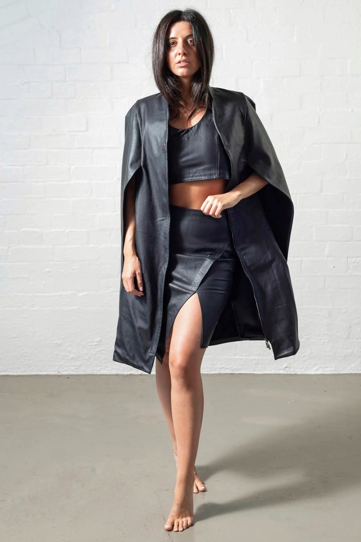 Leather asymmetrical skirt worn with vest and cape